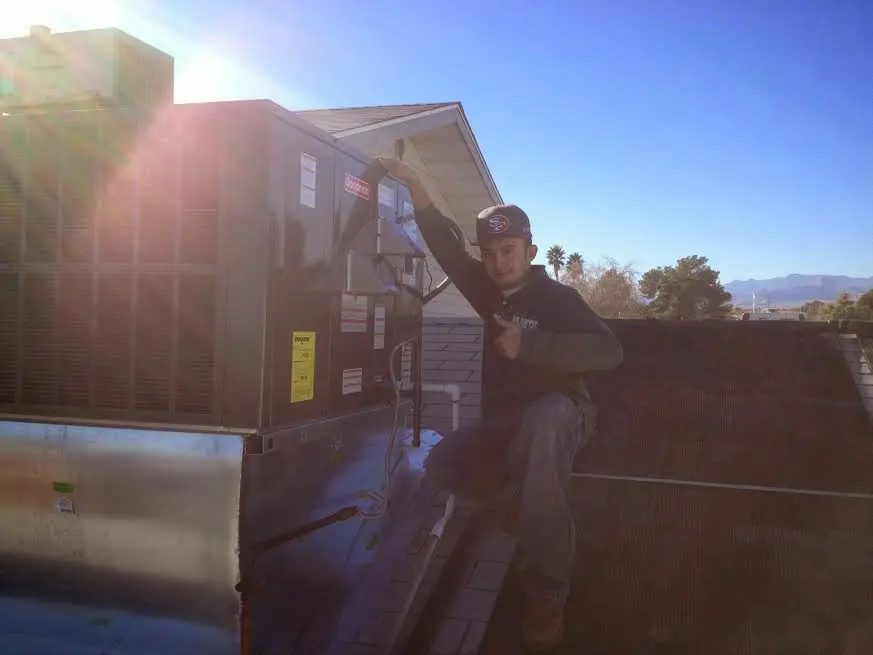 HVAC technician performing Air Duct Repair on a rooftop unit in Weiser