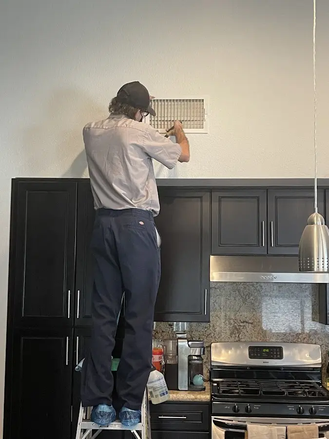 Technician inspecting an air vent during HVAC service in Weiser